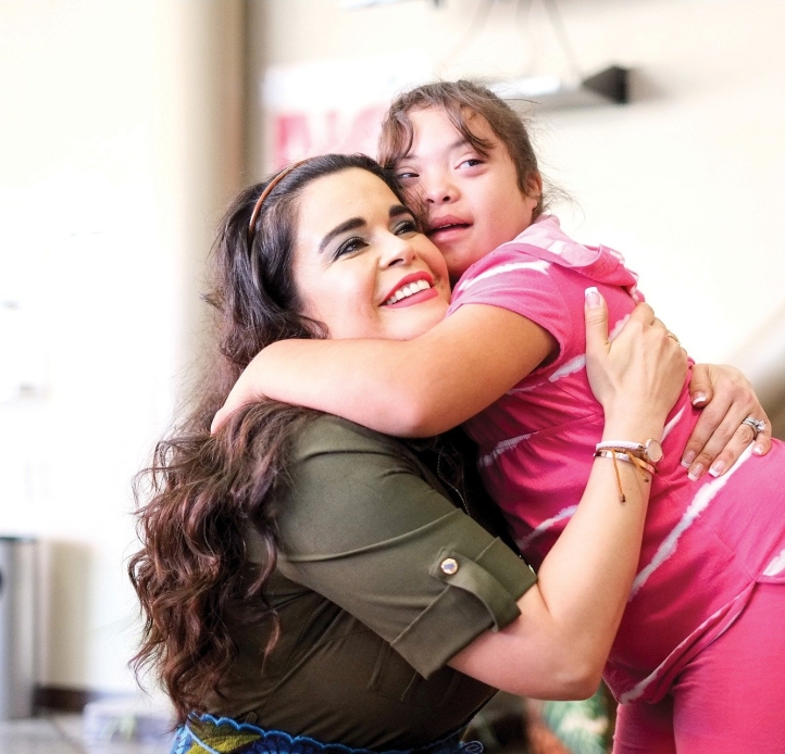 Student with down's syndrome hugs special education teacher